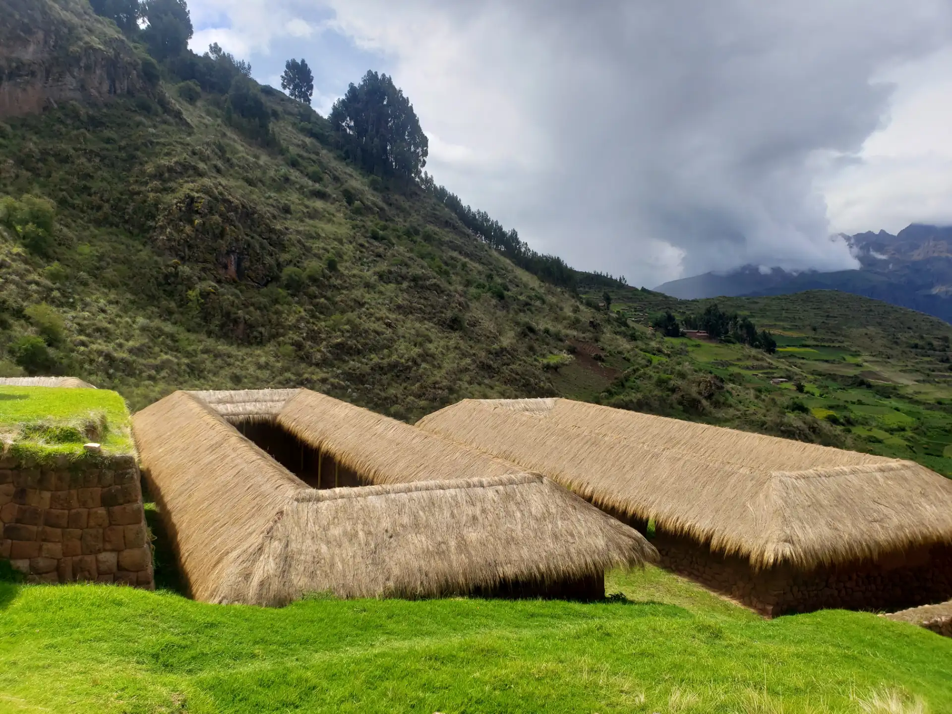 Restored buildings with thatched roofs at Huchuy Qosqo.