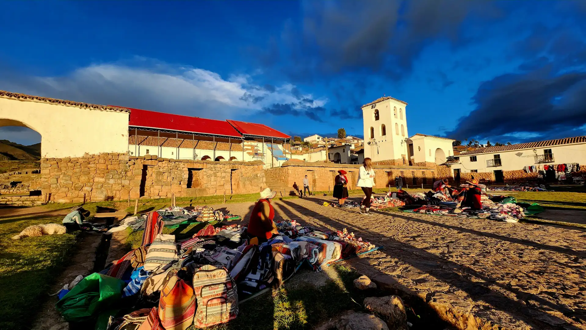 Textiles laid out in front of the colonial church of Chinchero.